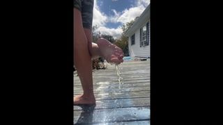 Wild big breasted woman pours milk on feet and soles outdoors